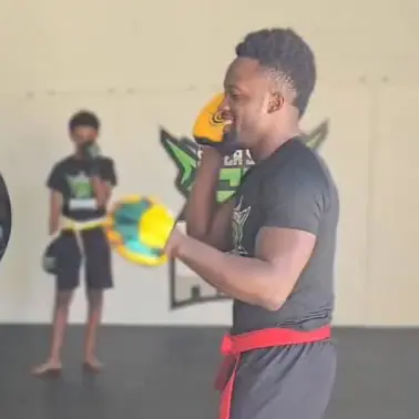 Sodiq Yusuff holding pads during a class at the Waldorf academy